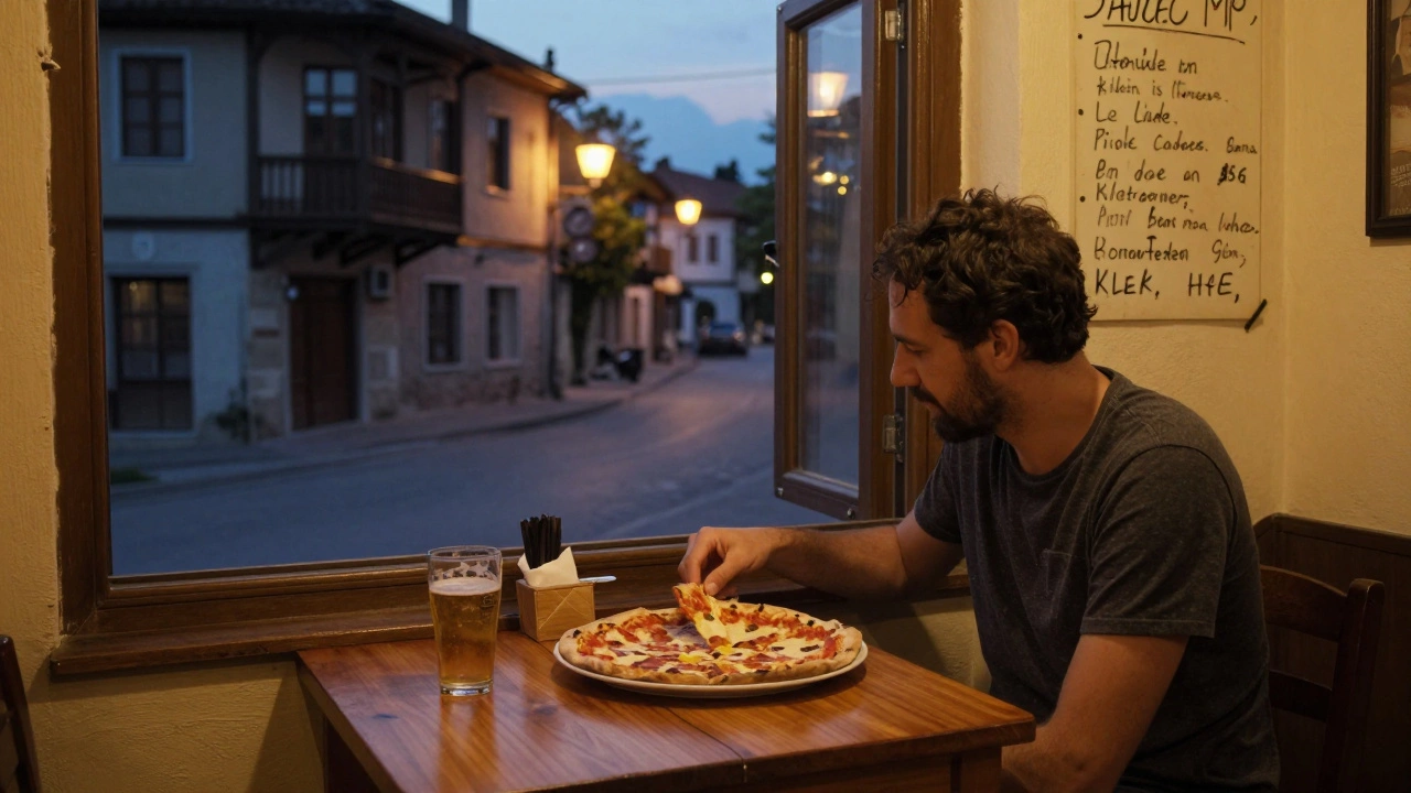 Уютная гостиница в Сербии, турист ест пиццу и пьёт пиво на фоне тихой улицы.